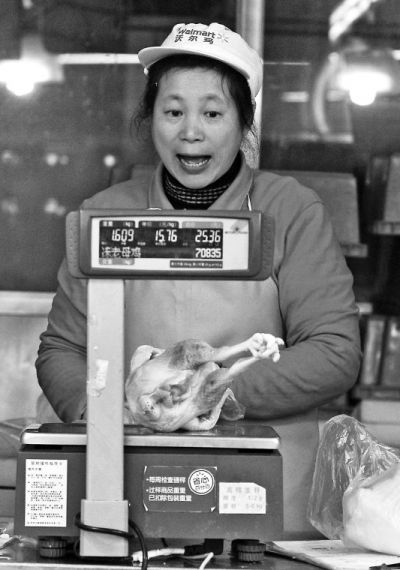 超市售货员正在对鸡肉称重